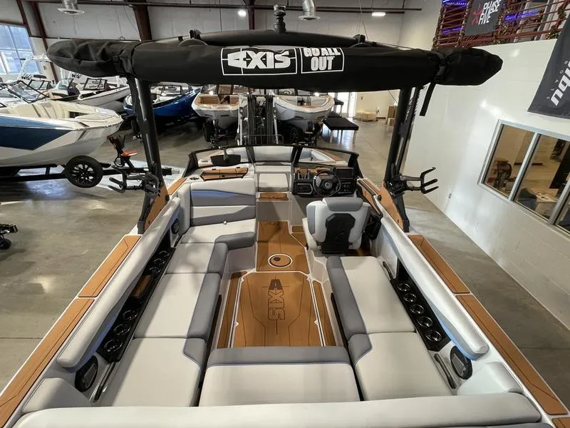 Slide: The Image of 2025 Axis A225 boat interior with spacious seating and modern design in a showroom. - 11