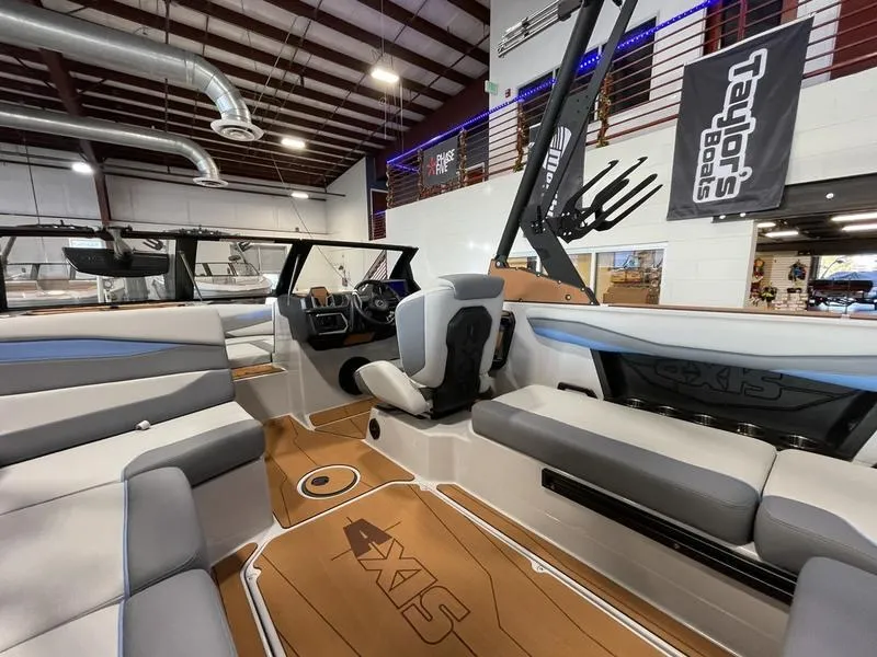 Slide: The Image of Interior of 2025 Axis A225 boat in showroom, featuring modern seating and dashboard. - 13