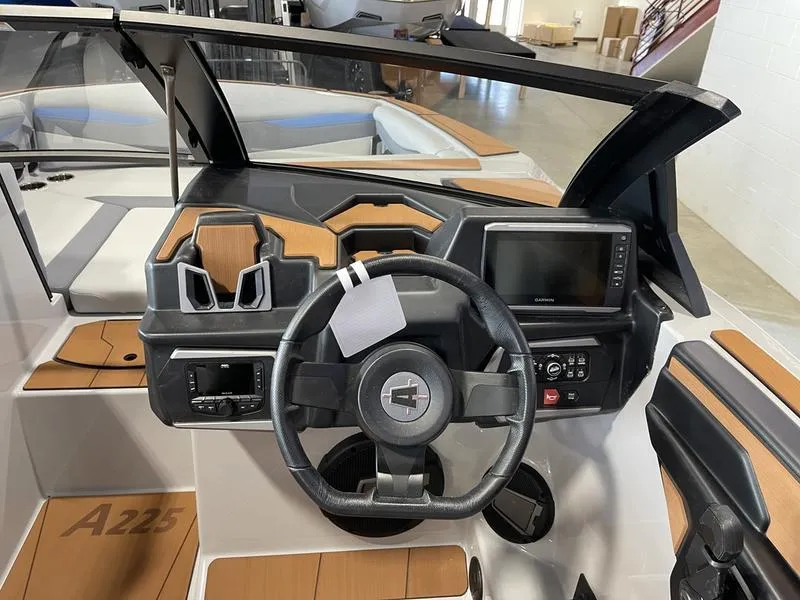 Slide: The Image of 2025 Axis A225 boat dashboard with steering wheel and navigation display. - 16