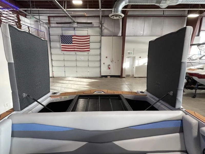 Slide: The Image of 2025 Axis A225 boat interior in a garage with American flag. - 24