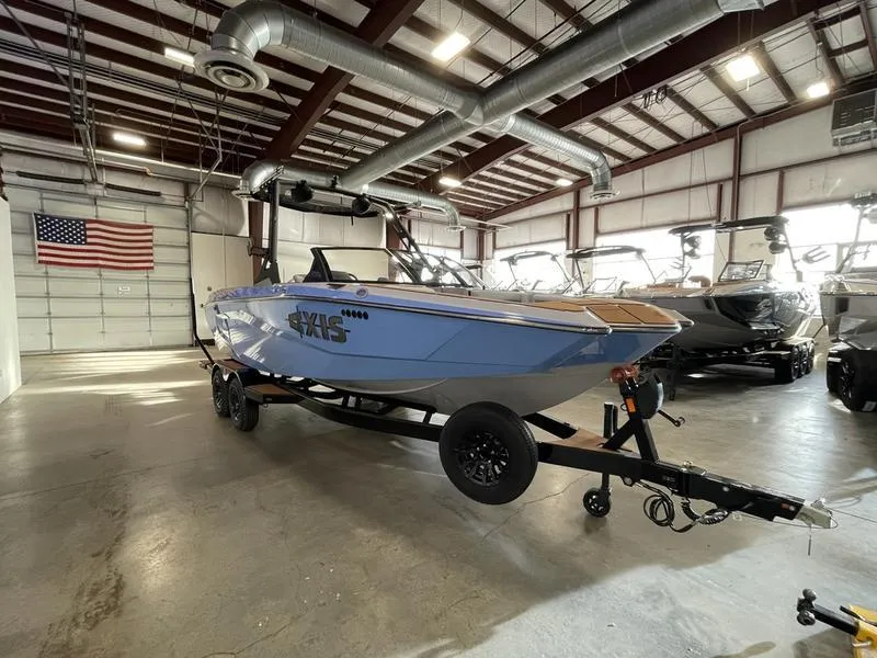 Slide: The Image of 2025 Axis A225 boat in a showroom, blue exterior, on a trailer. - 5