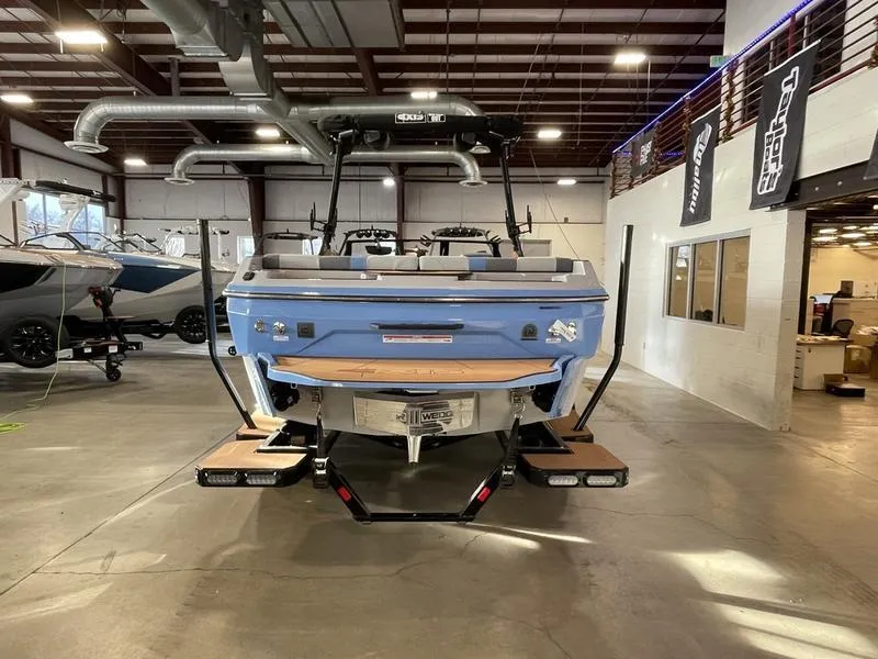 Slide: The Image of 2025 Axis A225 boat in showroom, rear view, blue exterior, modern design. - 8