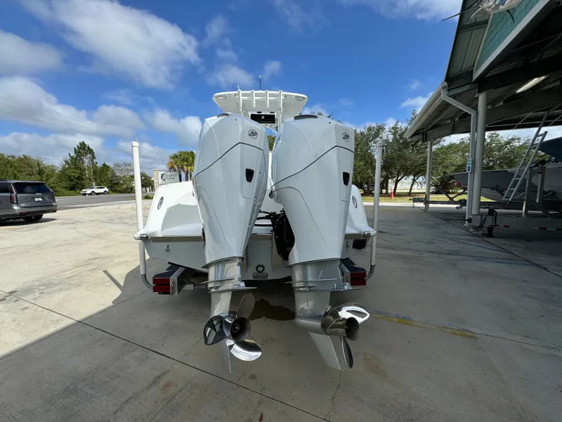 Slide: The Image of 2024 Front Runner 26 Center Console with dual outboard motors in a sunny marina. - 15