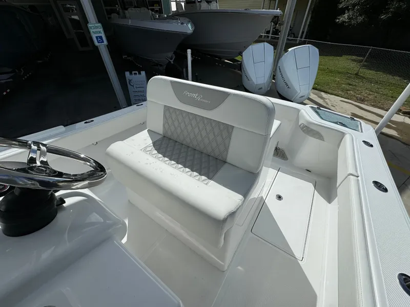 Slide: The Image of 2024 Front Runner 26 Center Console boat interior with white seating and steering wheel. - 27