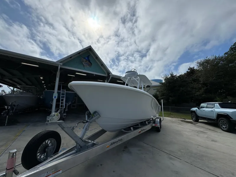 Slide: The Image of 2024 Front Runner 26 Center Console boat on trailer, parked outdoors under cloudy sky. - 3