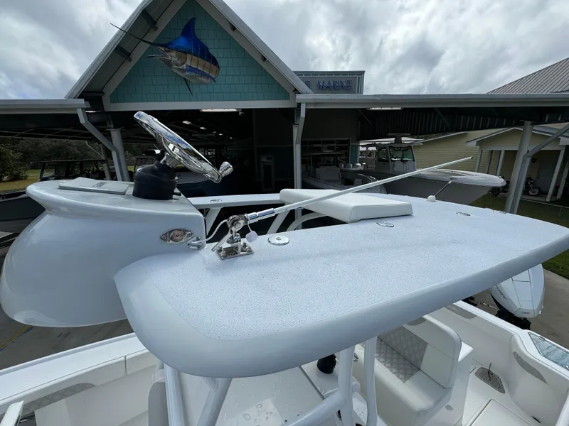 Slide: The Image of 2024 Front Runner 26 Center Console boat helm with steering wheel and controls. - 36