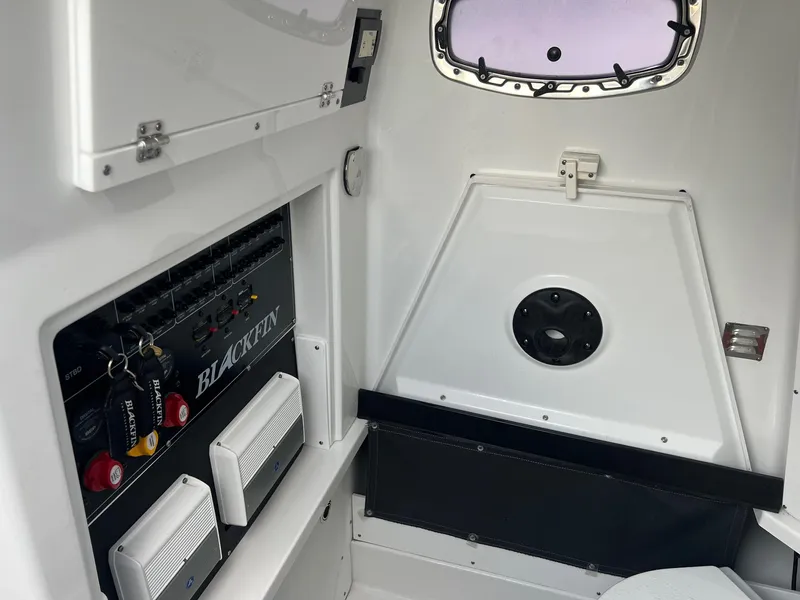 Slide: The Image of Interior of 2023 Blackfin 272 CC boat, featuring control panel and storage area. - 15