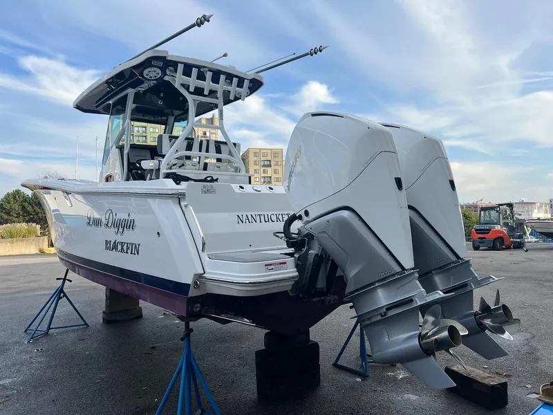 Slide: The Image of 2023 Blackfin 272 CC boat with dual engines on display in a marina. - 3