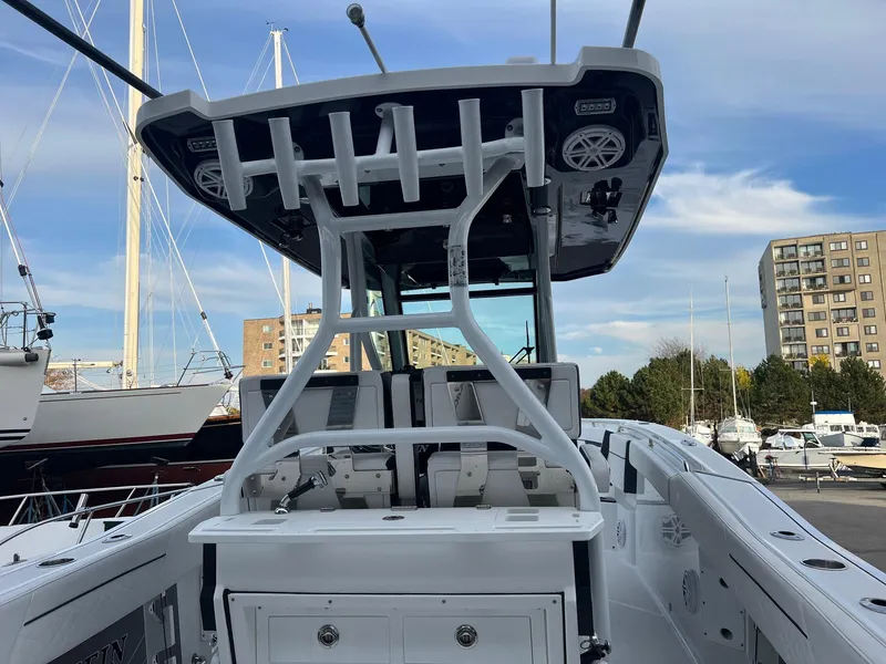 Slide: The Image of 2023 Blackfin 272 CC boat interior with T-top and rod holders at marina. - 5