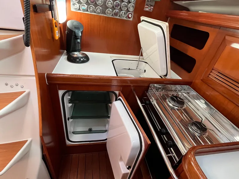 Slide: The Image of Beneteau Oceanis 393 yacht kitchen with stove, fridge, and wooden cabinetry, 2001 model. - 15