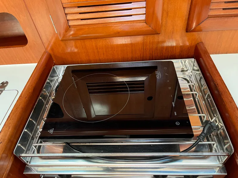 Slide: The Image of Induction cooktop in Beneteau Oceanis 393 yacht kitchen, 2001 model, with wooden cabinetry. - 16