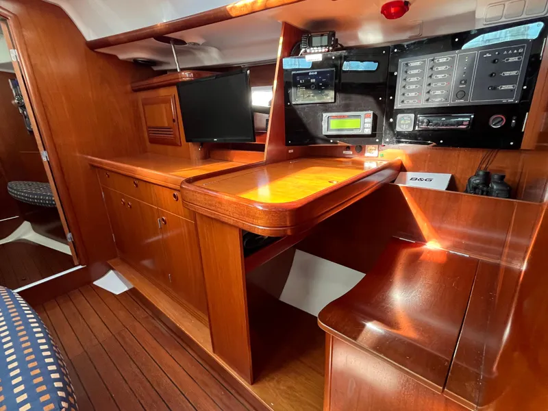 Slide: The Image of Interior of 2001 Beneteau Oceanis 393 sailboat with navigation station and wooden cabinetry. - 19