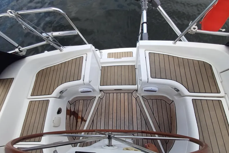 Slide: The Image of Beneteau Oceanis 393 cockpit with teak flooring, 2001 model, featuring a wooden steering wheel. - 36