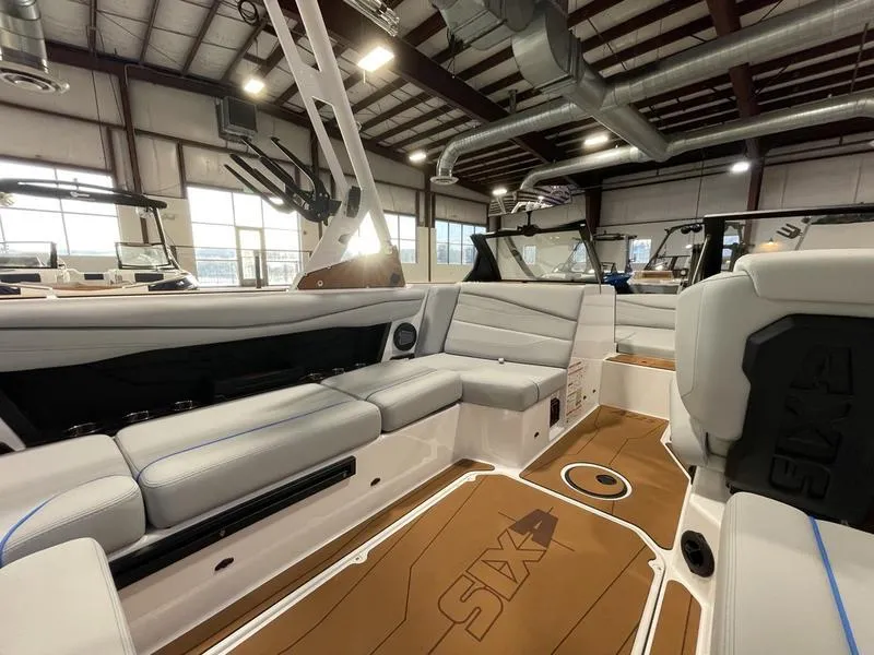 Slide: The Image of 2025 Axis A225 boat interior with modern seating and sleek design in a showroom. - 13