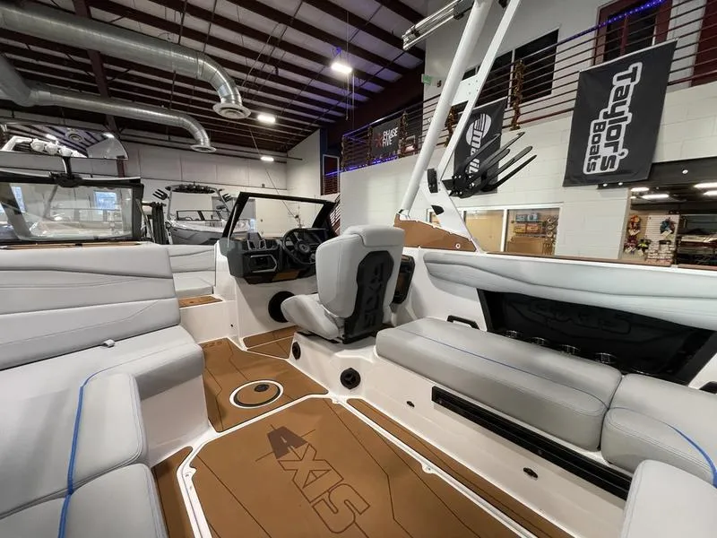 Slide: The Image of Interior of 2025 Axis A225 boat with modern seating and dashboard in showroom. - 14
