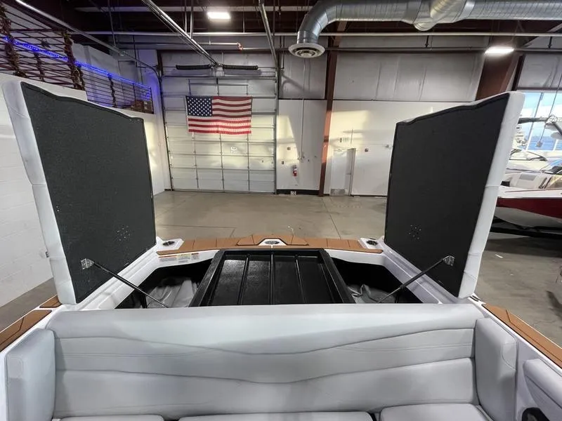 Slide: The Image of 2025 Axis A225 boat interior with open storage compartments in a warehouse setting. - 26