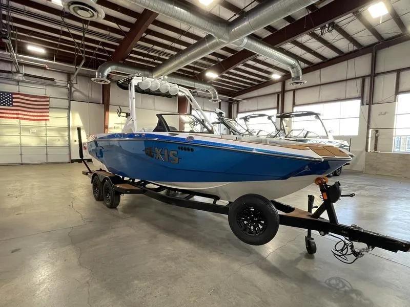 Slide: The Image of 2025 Axis A225 boat in a warehouse, blue and white design, on a trailer. - 6