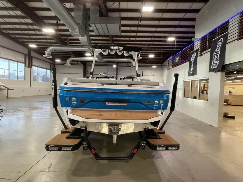 Slide: The Image of 2025 Axis A225 boat in showroom, rear view, blue and white design. - 8