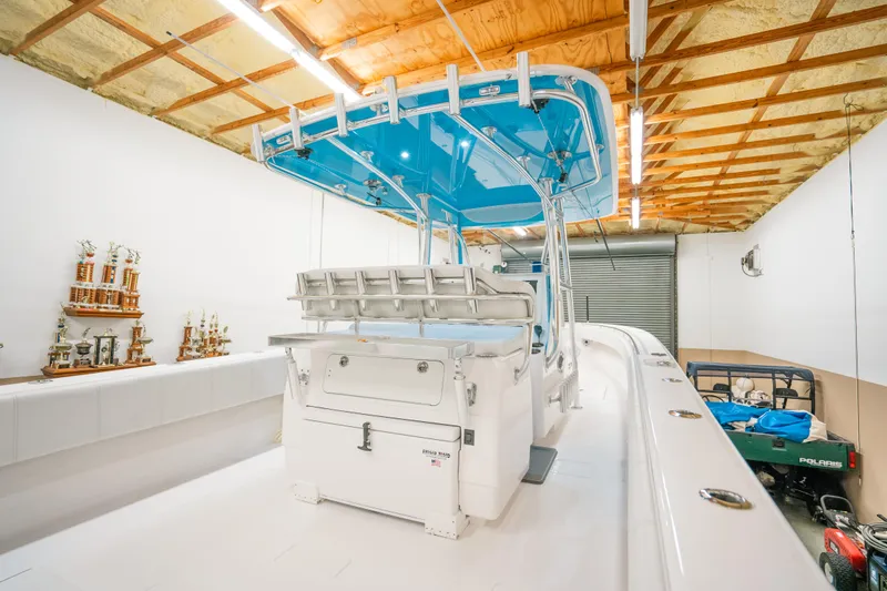 Slide: The Image of 2023 Contender 39 ST boat in a garage with trophies on shelves. - 14