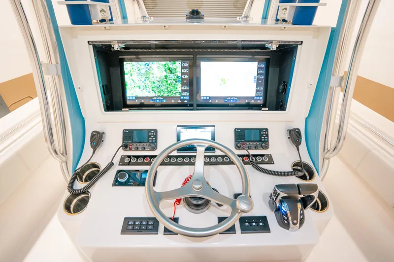 Slide: The Image of 2023 Contender 39 ST boat dashboard with dual screens and steering wheel. - 18