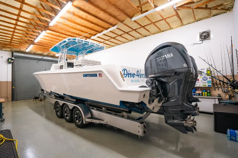 Slide: The Image of 2023 Contender 39 ST boat in garage with Yamaha outboard motor. - 2