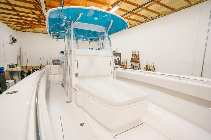 Slide: The Image of 2023 Contender 39 ST boat with blue canopy in a spacious indoor setting. - 23