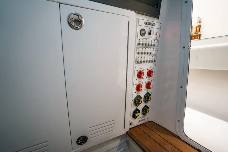 Slide: The Image of Contender 39 ST 2023 control panel with switches and storage compartment. - 33