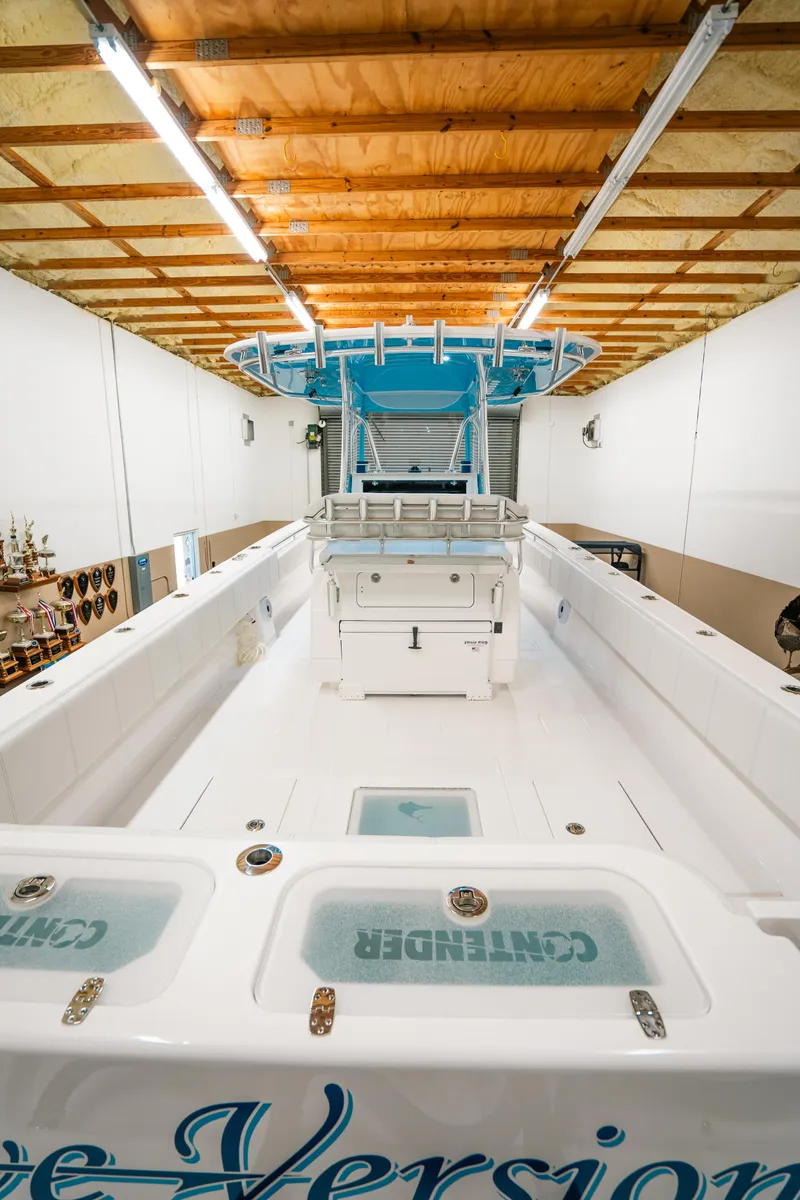 Slide: The Image of 2023 Contender 39 ST boat in a well-lit indoor storage facility. - 9