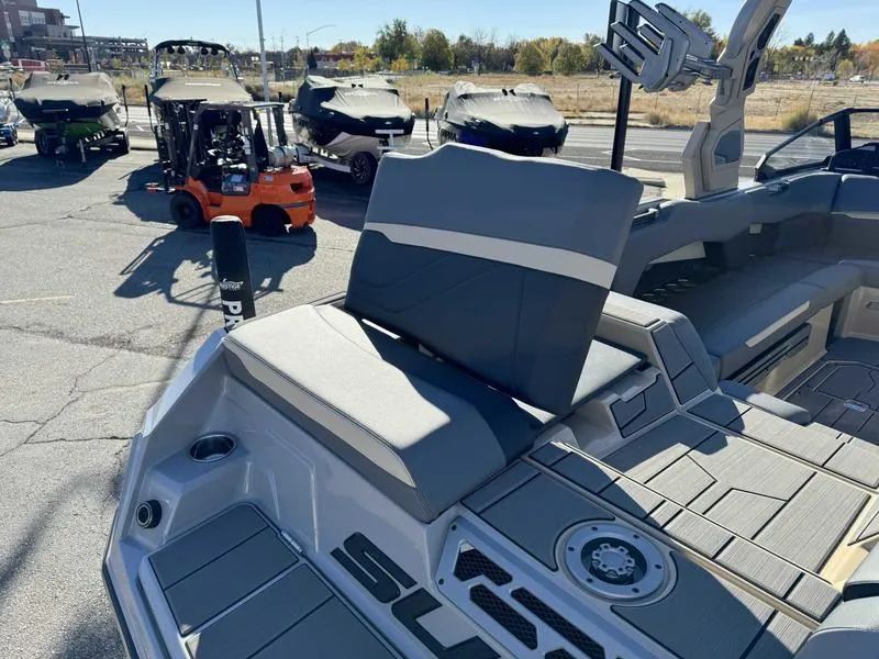 Slide: The Image of 2025 Supra SE boat interior with seating and deck, parked outdoors. - 1