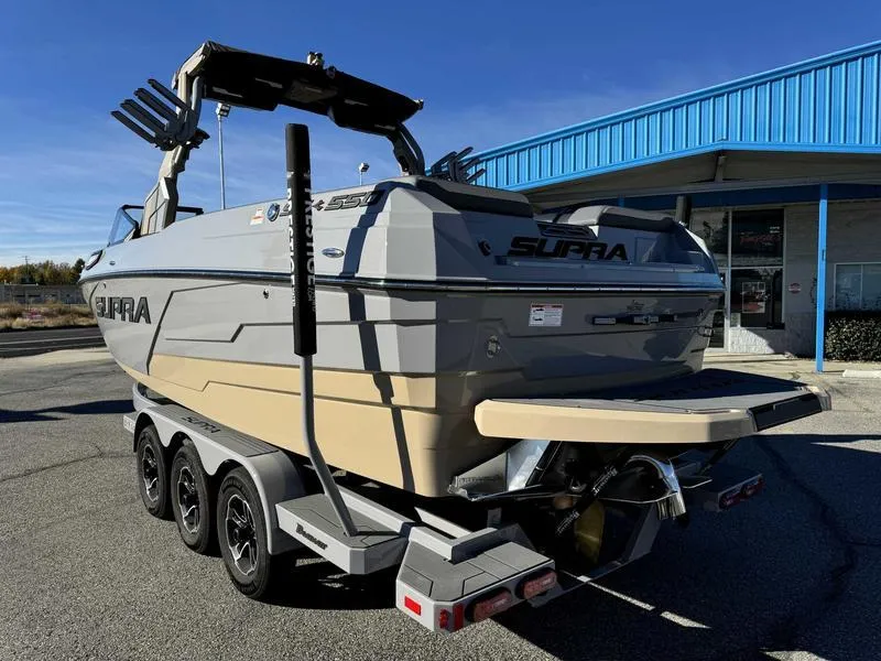 Slide: The Image of 2025 Supra SE boat on trailer, parked outside a blue building. - 5