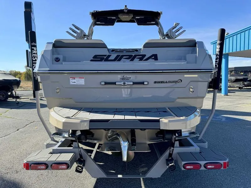 Slide: The Image of 2025 Supra SE boat rear view with swim platform and wakeboard racks. - 6