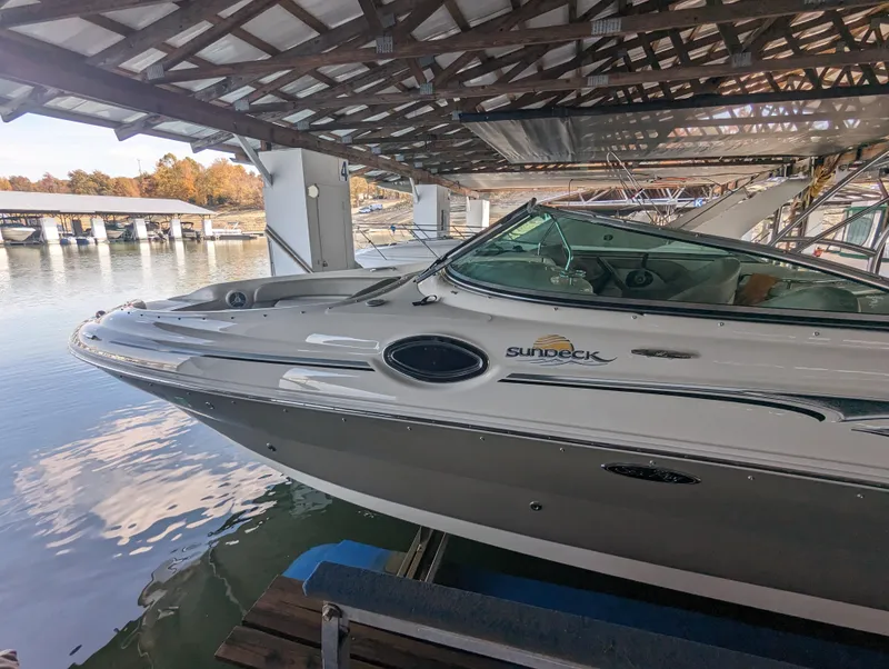 Slide: The Image of 2006 Sea Ray 240 Sundeck boat docked under a covered marina. - 13