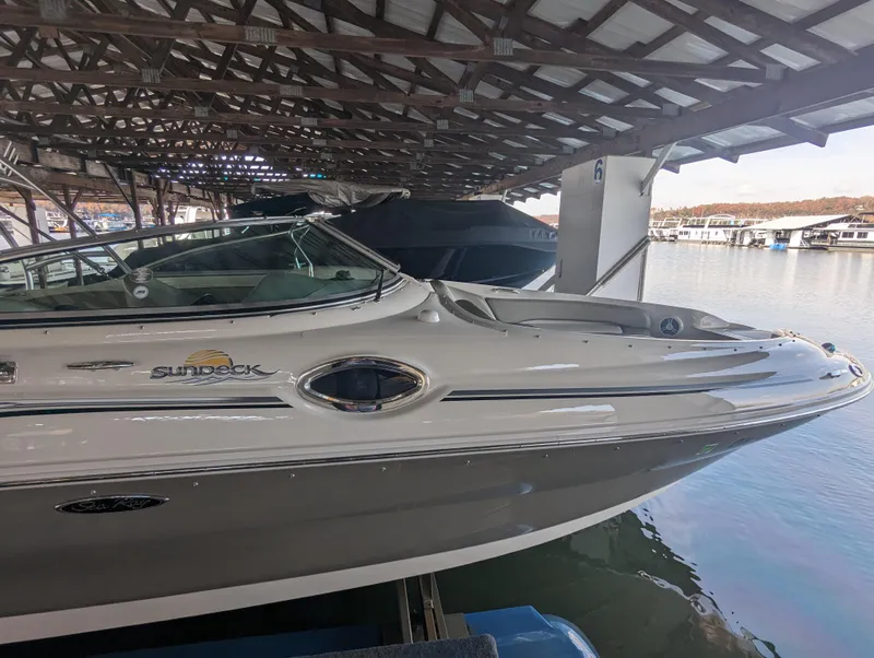 Slide: The Image of 2006 Sea Ray 240 Sundeck boat docked under a covered marina. - 17
