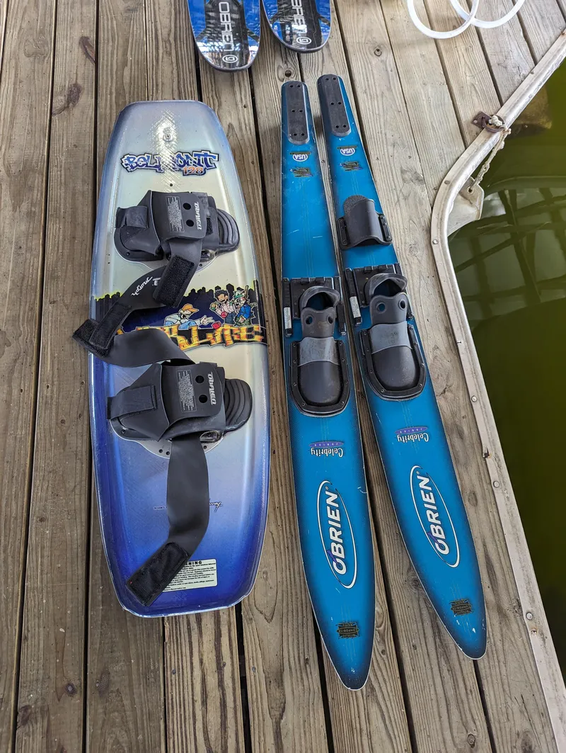Slide: The Image of Wakeboard and O'Brien water skis on wooden dock near water. - 21