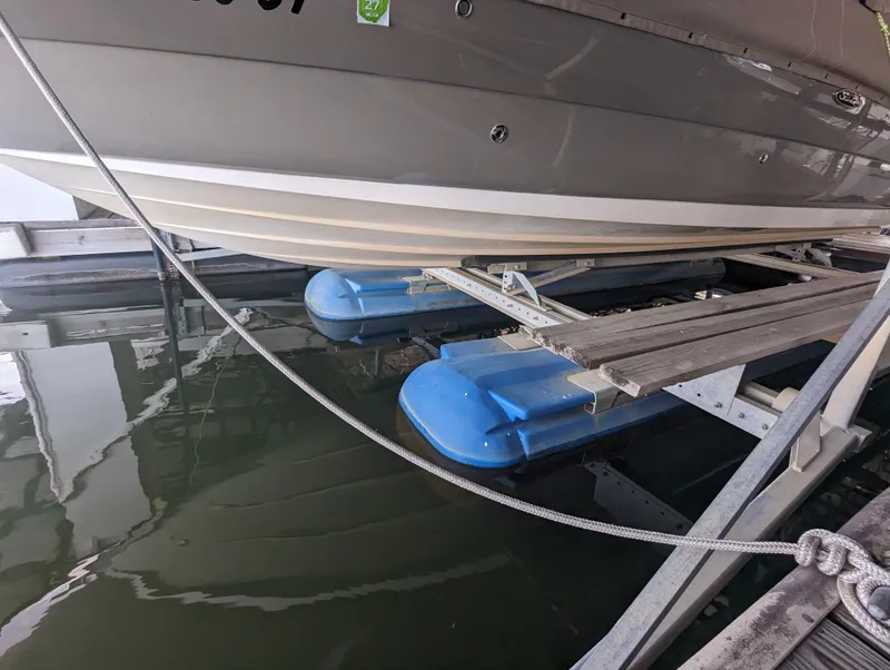 Slide: The Image of 2006 Sea Ray 240 Sundeck on boat lift with blue supports. - 3