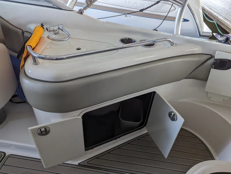 Slide: The Image of 2006 Sea Ray 240 Sundeck interior with open storage compartment and safety equipment. - 33