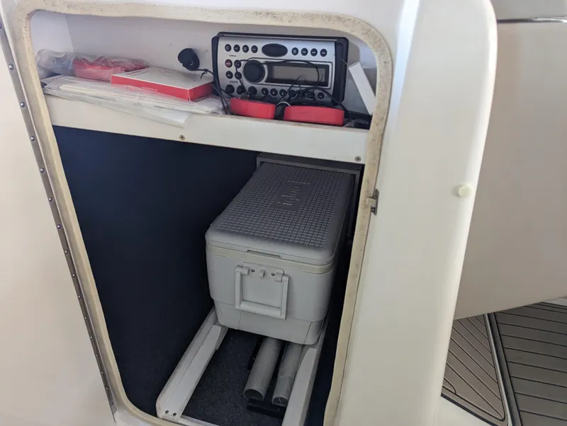 Slide: The Image of 2006 Sea Ray 240 Sundeck storage compartment with radio and cooler. - 37