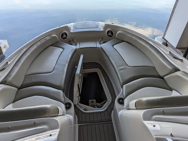 Slide: The Image of 2006 Sea Ray 240 Sundeck interior with cushioned seating and storage compartment. - 42