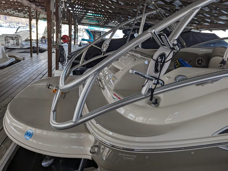 Slide: The Image of 2006 Sea Ray 240 Sundeck boat docked under a covered marina. - 6