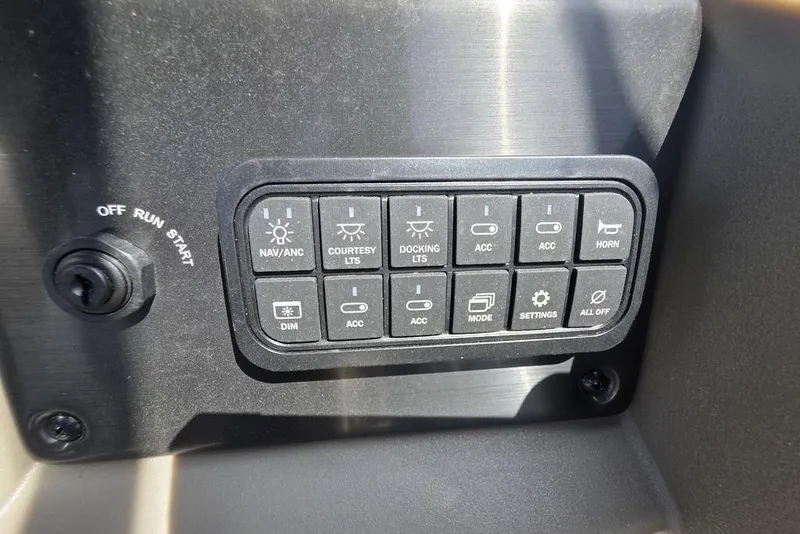 Slide: The Image of Control panel of 2025 Sun Tracker Party Barge 22 DLX with various switches and settings. - 19