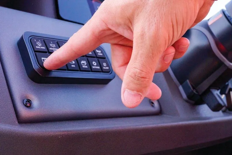 Slide: The Image of Hand pressing button on 2025 Sun Tracker Party Barge 22 DLX control panel. - 25