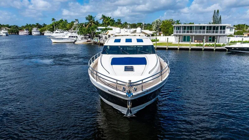 Slide: The Image of Luxury 2010 Princess V78 yacht on a serene waterway, surrounded by modern homes. - 12