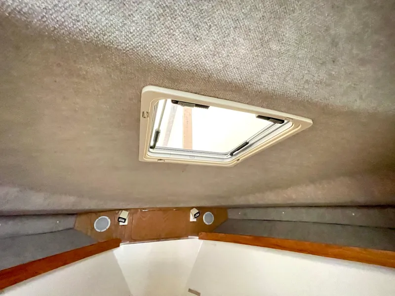 Slide: The Image of Interior cabin view of a 1999 Henriques 28 Express boat, featuring a ceiling hatch. - 14