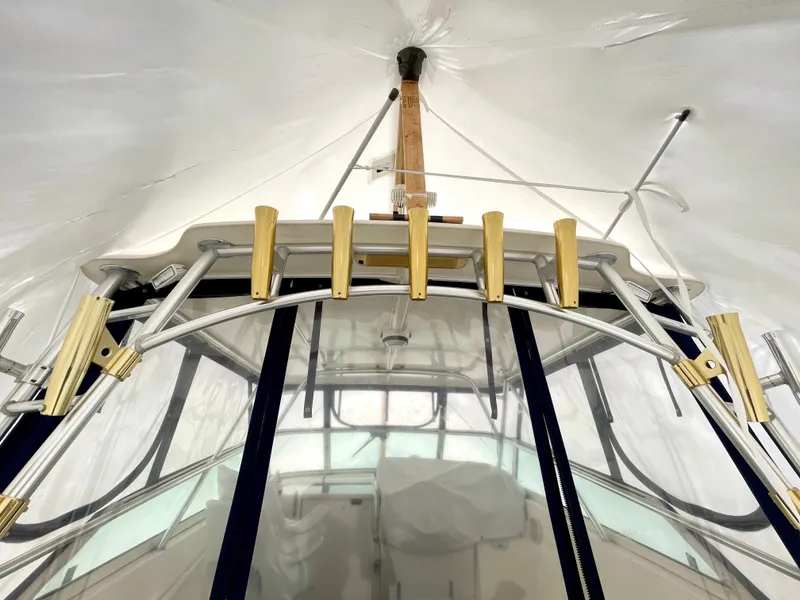 Slide: The Image of 1999 Henriques 28 Express boat under cover, featuring rod holders and cockpit view. - 22