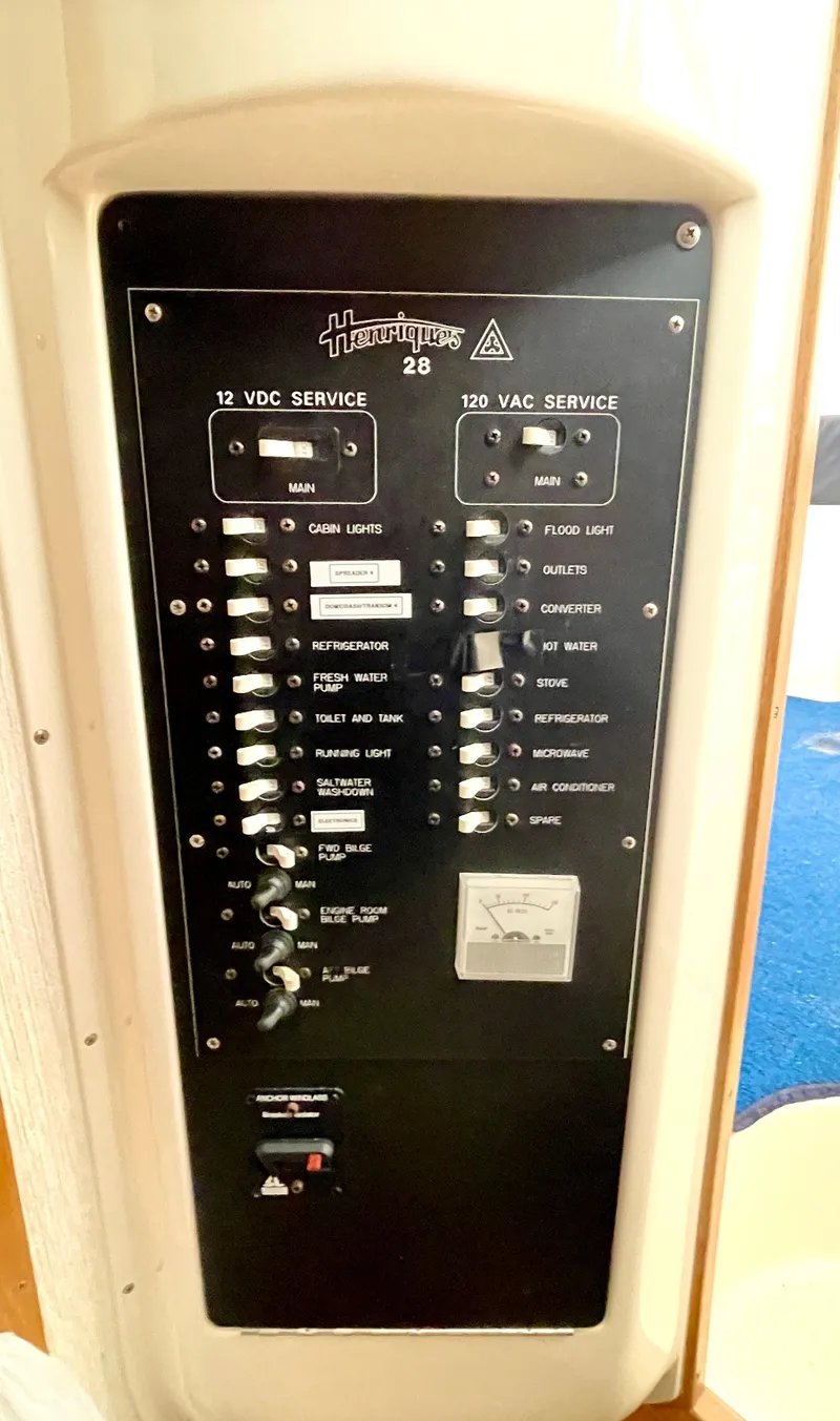 Slide: The Image of Electrical panel of a 1999 Henriques 28 Express boat, showing 12 VDC and 120 VAC services. - 24