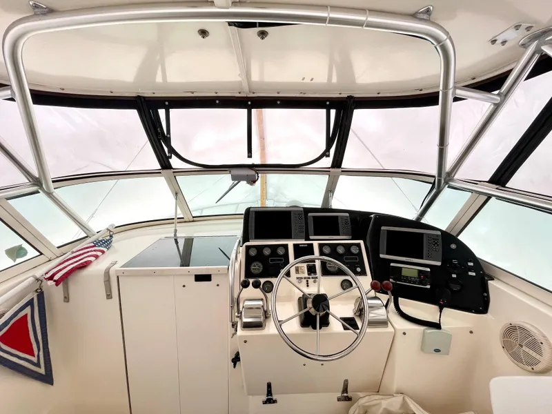 Slide: The Image of 1999 Henriques 28 Express boat helm with steering wheel and navigation instruments. - 3