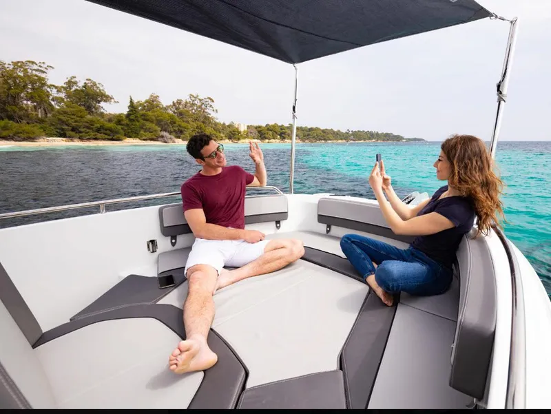 Slide: The Image of Couple relaxing on 2023 Jeanneau Leader 7.5CC boat, enjoying scenic ocean view. - 11