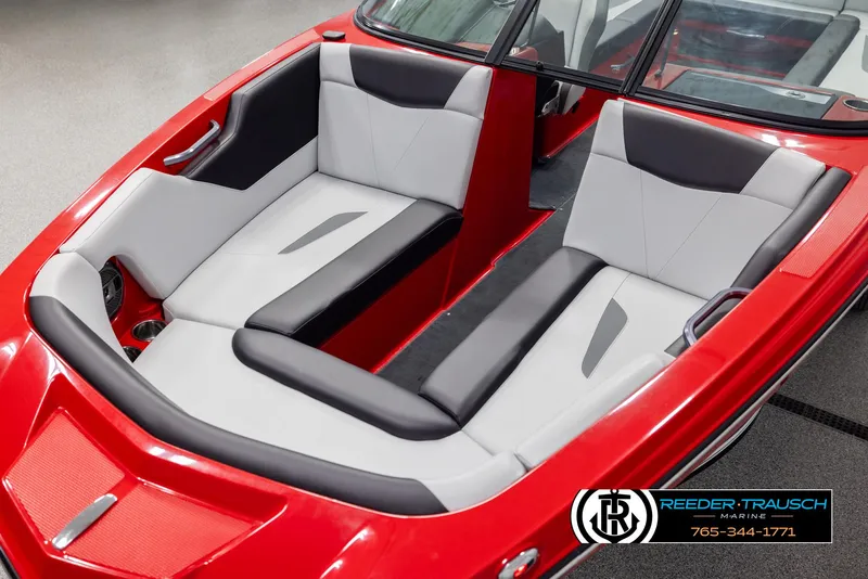 Slide: The Image of 2021 MasterCraft NXT24 boat interior with red and gray seating, Reeder-Trausch Marine logo. - 10