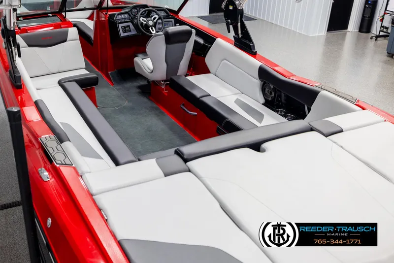 Slide: The Image of 2021 MasterCraft NXT24 boat interior with red and white seating, steering console, and logo. - 11
