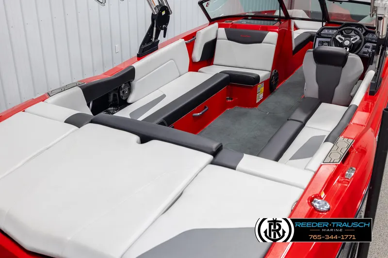 Slide: The Image of 2021 MasterCraft NXT24 boat interior with red and white seating, steering wheel, and dashboard. - 12
